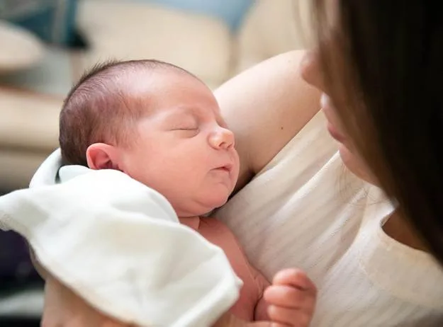 A mother holding her sleeping newborn