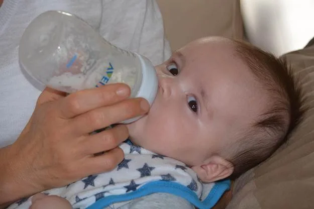 A parent bottle-feeding a baby